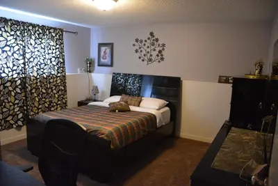 a bedroom with a bed with a cat laying on it at Aasra Home in Kelowna