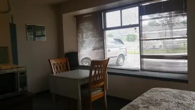 a bedroom with a table and two chairs and a window at Evergreen Motel in Princeton