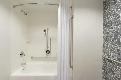 a bathroom with a shower and a white sink at Hilton Garden Inn Calgary Downtown in Calgary