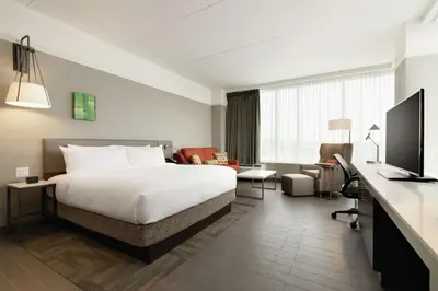 a hotel room with a bed and a living room at Hilton Garden Inn Calgary Downtown in Calgary