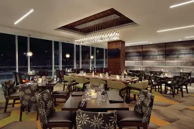 a restaurant with tables and chairs and windows at Homewood Suites by Hilton Calgary Downtown in Calgary