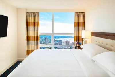 a hotel room with a large bed and a large window at Sheraton Vancouver Wall Centre in Vancouver