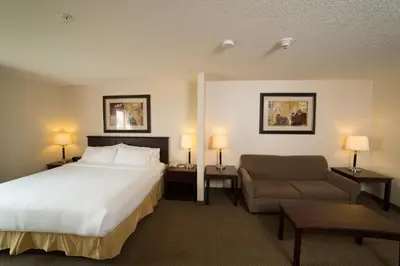 a hotel room with a bed and a chair at Holiday Inn Express & Suites Whitecourt by IHG in Whitecourt