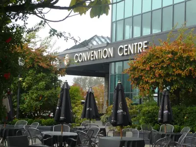 an outdoor cafe with tables and umbrellas in front of a building at Executive Suites Hotel & Conference Center, Metro Vancouver in Burnaby