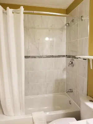a bathroom with a tub and a toilet and a sink at Sun Plaza Motel in Sundre