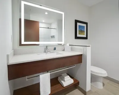 a bathroom with a sink and a mirror and a toilet at Four Points by Sheraton Sherwood Park in Sherwood Park