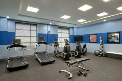 a gym with cardio equipment and a blue wall at Four Points by Sheraton Sherwood Park in Sherwood Park
