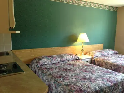 a hotel room with two beds and a green wall at Sundre Motor Inn in Sundre