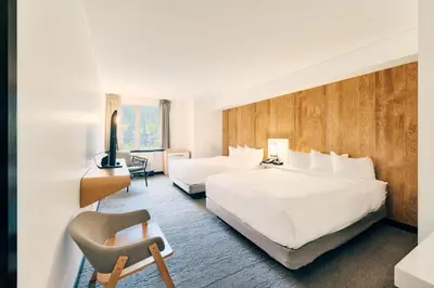 a hotel room with two beds and a chair at Aava Whistler Hotel in Whistler