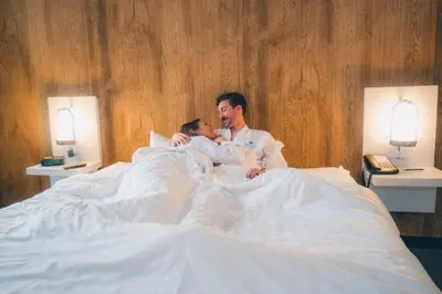 a man and a child laying in bed at Aava Whistler Hotel in Whistler