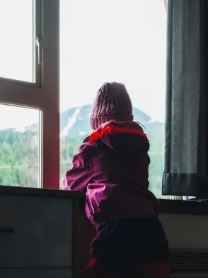 a person is looking out of a window at Aava Whistler Hotel in Whistler