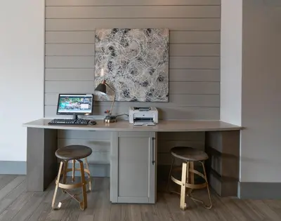 a desk with a computer and two stools at Prestige Vernon Lodge in Vernon