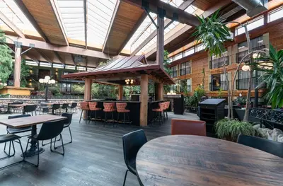 a restaurant with tables and chairs in a building at Prestige Vernon Lodge in Vernon