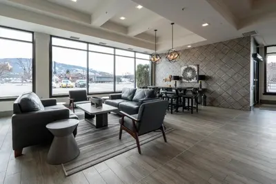 a living room with couches and chairs and a table at Prestige Vernon Lodge in Vernon