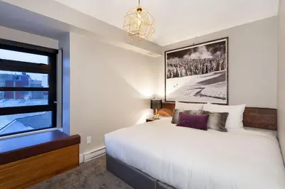 a bedroom with a white bed and a window at Gibbons Life Accommodations in Whistler
