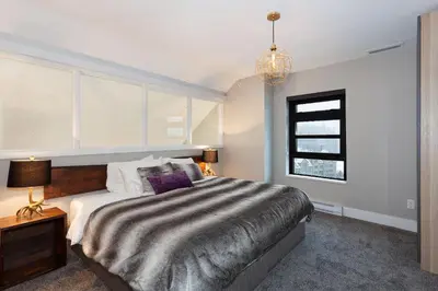 a bedroom with a large bed and a window at Gibbons Life Accommodations in Whistler