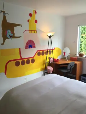 a bedroom with a large bed and a desk at A Room at the Camelia Bed and Breakfast in Tsawwassen