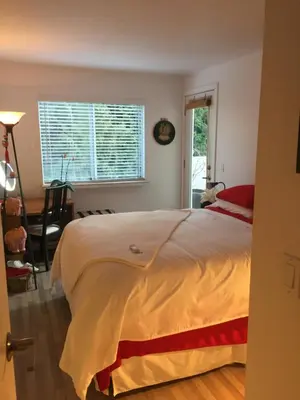 a bedroom with a large bed and a window at A Room at the Camelia Bed and Breakfast in Tsawwassen