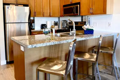 a kitchen with a sink and a counter with stools at Copper Oasis in West Kelowna