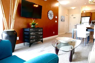 a living room with a tv and a dining room at Copper Oasis in West Kelowna