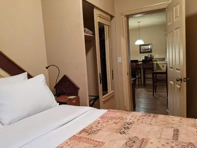 a bedroom with a bed and a dining room at Third Mission Heritage Suites in Peace River