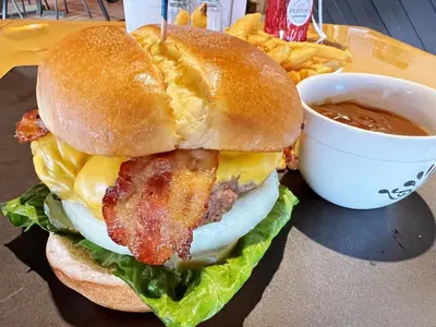 a sandwich with bacon and a cup of dipping sauce at Riverside Inn in Wabasca