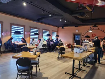 a group of people sitting at tables in a room at Riverside Inn in Wabasca