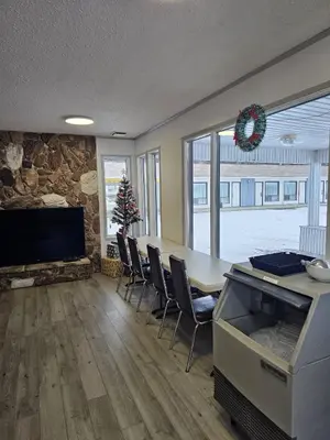 a living room with a table and chairs and a tv at Howard Johnson by Wyndham Edson in Edson