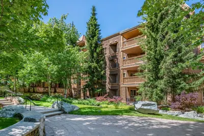 an apartment building with a pathway and trees at Hilton Grand Vacations Club Whistler in Whistler