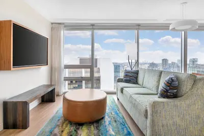 a living room with a couch and a large window at Embarc Vancouver in Vancouver