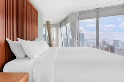 a bedroom with a white bed and a large window at Embarc Vancouver in Vancouver