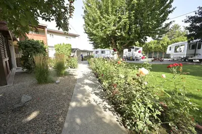a garden with a sidewalk and flowers in a yard at Maple Leaf Motel & RV Park Resort in Oliver