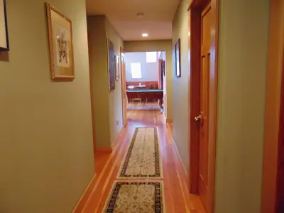 a hallway with a rug on a wooden floor at Paradise Acres Ranch in Nanoose Bay