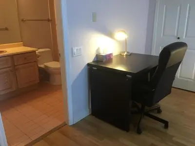 a desk with a lamp and a chair in a bathroom at Vancouver Homestay Inn in Richmond