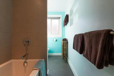 a bathroom with a bath tub and a window at Cloudside Hotel in Nelson