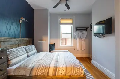 a bedroom with a large bed and a television at Cloudside Hotel in Nelson