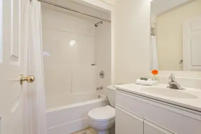 a white bathroom with a toilet and a sink at Mountainview 1 bedroom suite with check in services king size bed walk to Village WIFI cable TV free parking boot and glove warmer in Pemberton