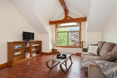 a living room with a couch and a table at Mountainview 1 bedroom suite with check in services king size bed walk to Village WIFI cable TV free parking boot and glove warmer in Pemberton