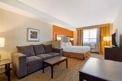 a hotel room with a couch and a bed at Best Western Plus Chateau Fort St. John in Fort Saint John