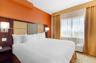 a bedroom with a large bed and a window at Best Western Plus Chateau Fort St. John in Fort Saint John