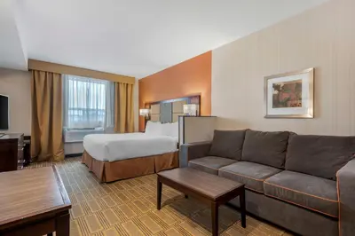 a hotel room with a couch and a bed at Best Western Plus Chateau Fort St. John in Fort Saint John
