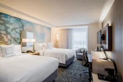 a hotel room with two beds and a television at Hotel Dene & Conference Centre in Cold Lake