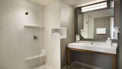 a bathroom with a sink and a mirror at Hotel Dene & Conference Centre in Cold Lake
