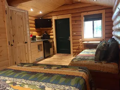 a bedroom with two beds in a log cabin at Port Hardy Cabins in Port Hardy