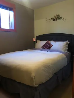 a bedroom with a large bed with white sheets and pillows at Mistiso's Place in Nelson