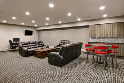 a living room with leather furniture and a table and chairs at Chateau Nova Yellowknife in Yellowknife