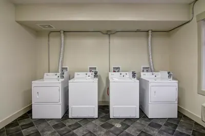 four washing machines are lined up in a room at Chateau Nova Yellowknife in Yellowknife