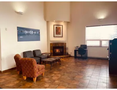 a living room with a couch and a fireplace at Aurora Park Inn & Suites in Dawson Creek