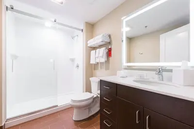 a bathroom with a toilet and a sink and a mirror at TownePlace Suites by Marriott Edmonton South in Edmonton