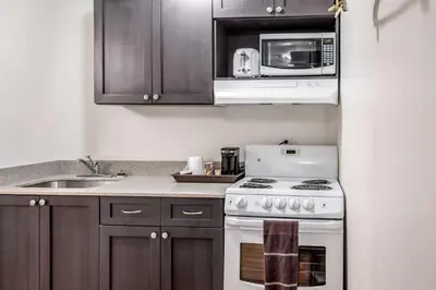 a kitchen with a white stove and a microwave at Motel 6-Fort Nelson, BC in Fort Nelson
